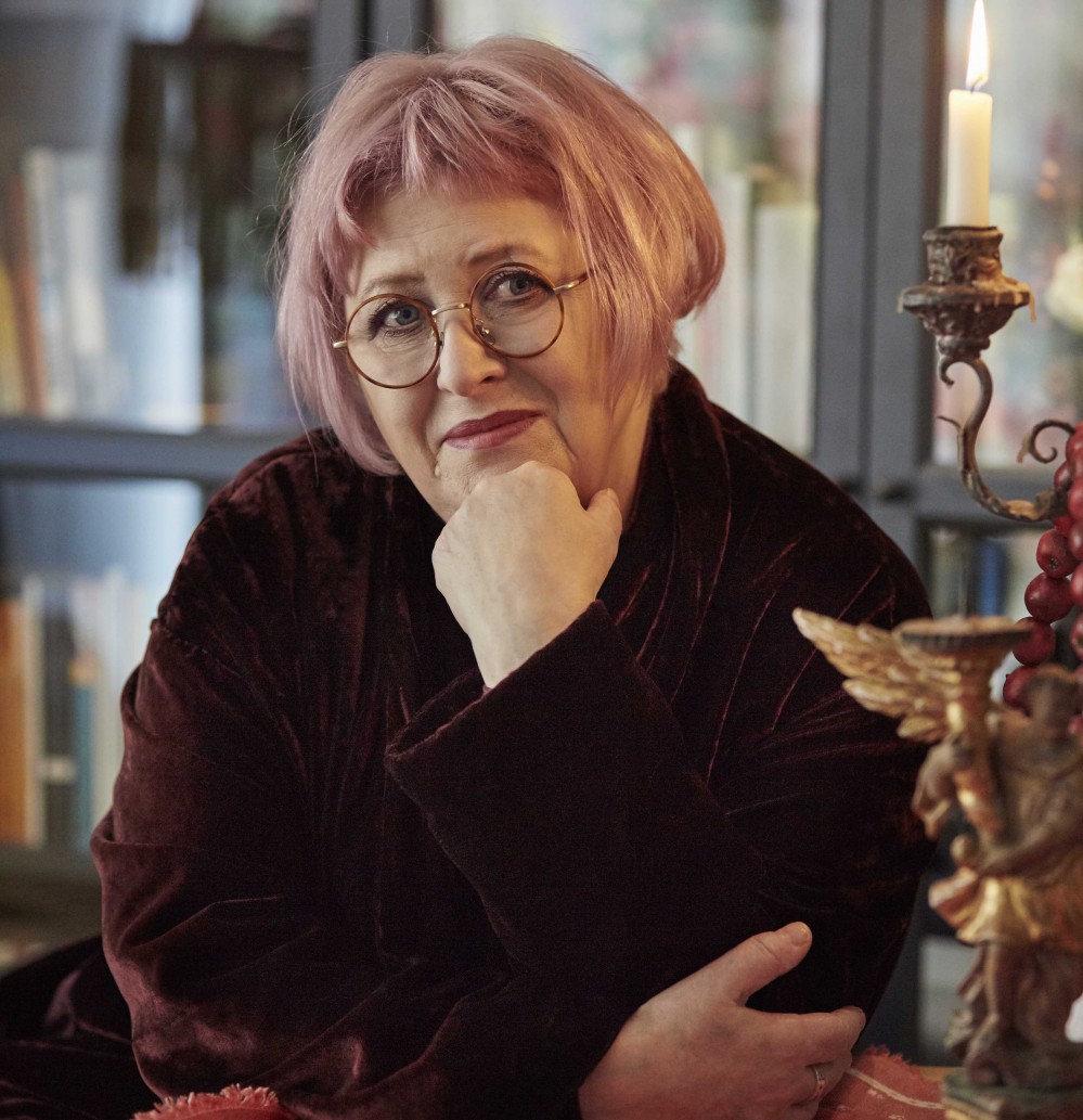 Sally Gardner smiling at the camera with a window in the background.