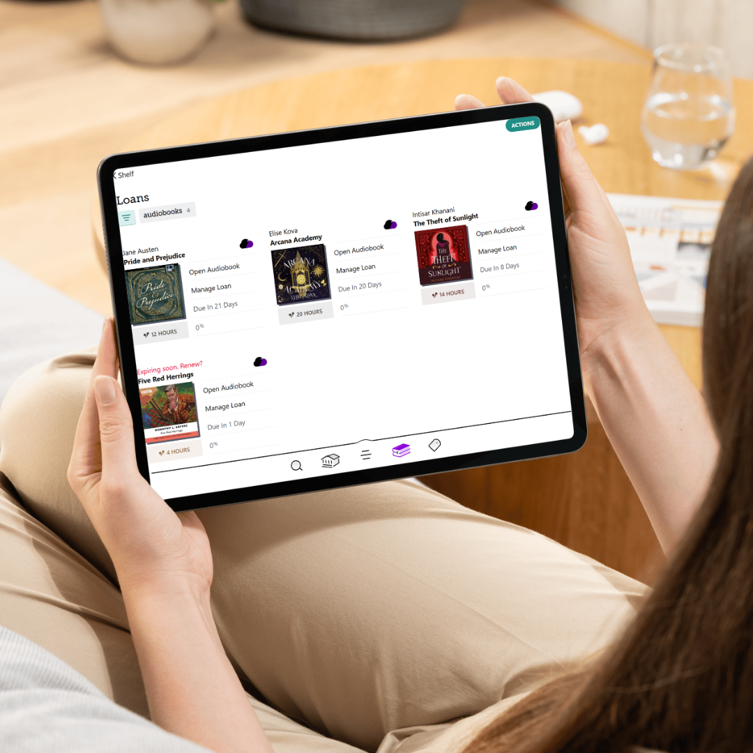 Person holding a tablet, with the Libby app on the screen. 